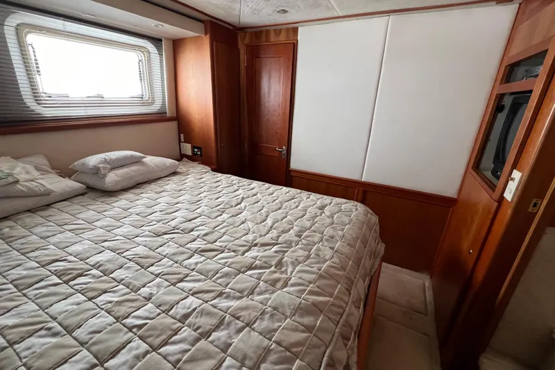 Sunflower Yacht Photos Pics Luxurious bedroom interior of 2002 Silverton 453 Motor Yacht with cozy bedding and wooden accents.