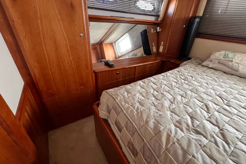 Sunflower Yacht Photos Pics Luxurious cabin interior of 2002 Silverton 453 Motor Yacht with wood paneling and cozy bedding.