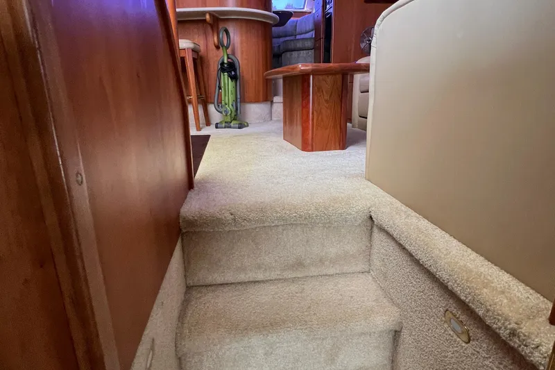 Sunflower Yacht Photos Pics Interior of 2002 Silverton 453 Motor Yacht with carpeted stairs and wooden furniture.
