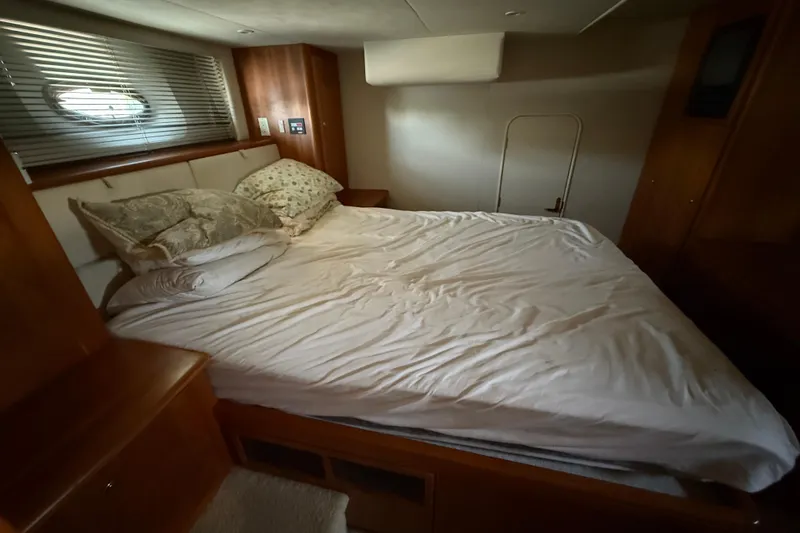 Sunflower Yacht Photos Pics Cozy bedroom interior of 2002 Silverton 453 Motor Yacht with bed and wooden furnishings.