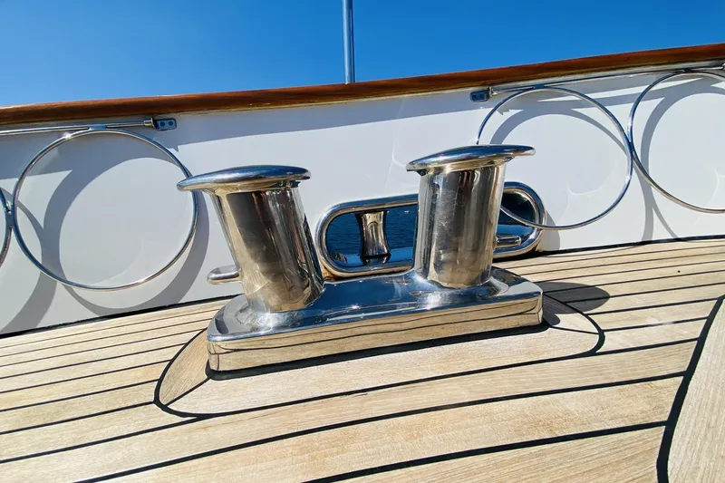  Yacht Photos Pics Polished steel cleat on Ada Yacht Steel Trawler, 2014, with wooden deck and blue sky.