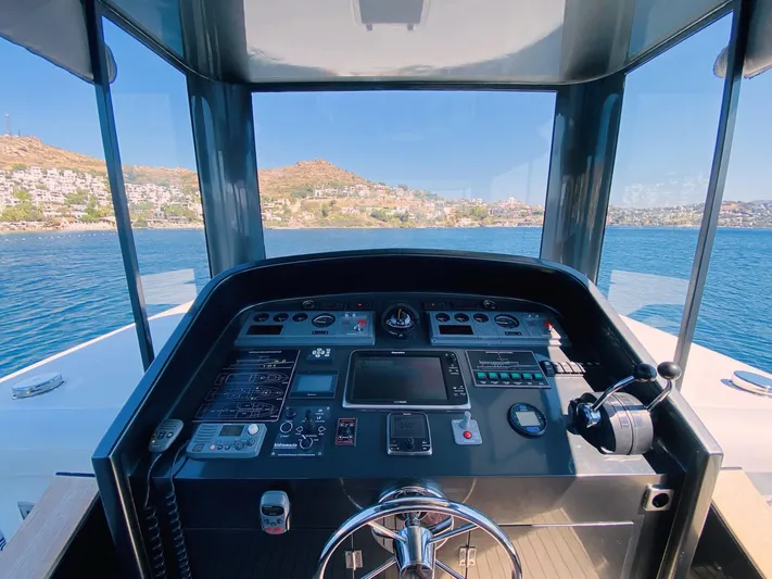  Yacht Photos Pics Pilothouse view of 2014 Ada Yacht Steel Trawler, overlooking serene waters and distant hills.