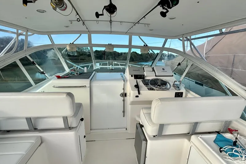 Niala Yacht Photos Pics 2004 Cabo 35 Express Sportfish helm with white seating and navigation equipment.