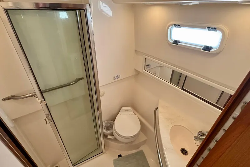 Niala Yacht Photos Pics 2004 Cabo 35 Express Sportfish bathroom with shower, sink, and porthole window.