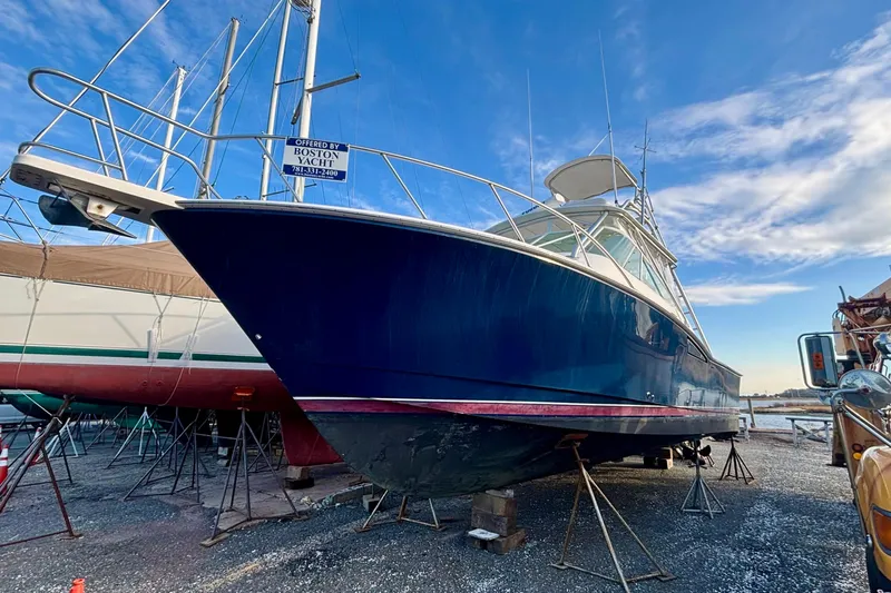 Niala Yacht Photos Pics 2004 Cabo 35 Express Sportfish boat on stands, blue hull, clear sky background.