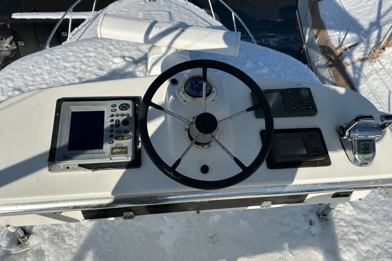 Niala Yacht Photos Pics Helm of 2004 Cabo 35 Express Sportfish with navigation equipment, covered in snow.