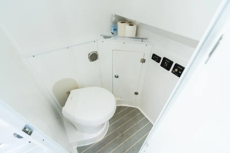  Yacht Photos Pics 2023 HCB 42 Lujo boat bathroom with toilet, storage, and control panels.