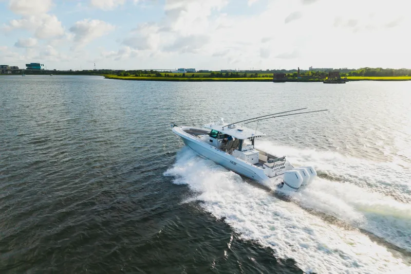  Yacht Photos Pics 2023 HCB 42 Lujo boat cruising on a sunny day, creating waves in open water.