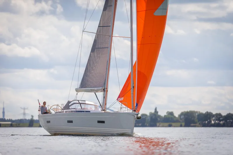  Yacht Photos Pics 2025 X-Yachts X4⁶ sailing yacht with vibrant orange sail on open water.