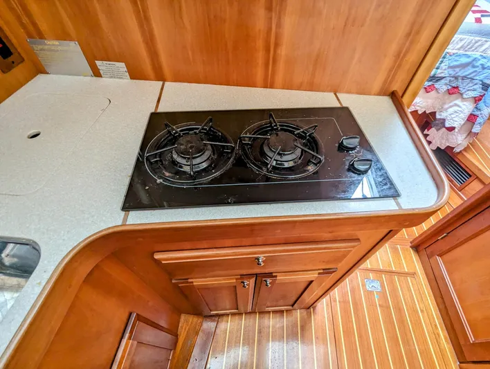  Yacht Photos Pics 2003 Sabre 36 Flybridge kitchen with two-burner stove and wooden cabinetry.