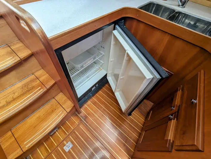  Yacht Photos Pics 2003 Sabre 36 Flybridge interior with open fridge, wooden flooring, and stairs.