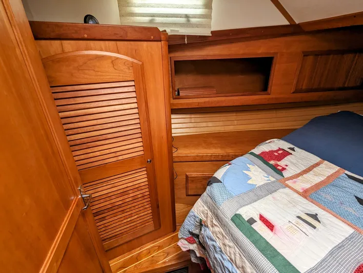  Yacht Photos Pics 2003 Sabre 36 Flybridge cabin interior with wooden cabinetry and colorful quilted bedspread.