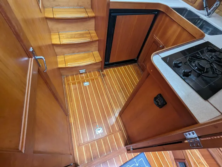  Yacht Photos Pics Interior of 2003 Sabre 36 Flybridge yacht with wooden flooring and compact kitchen area.