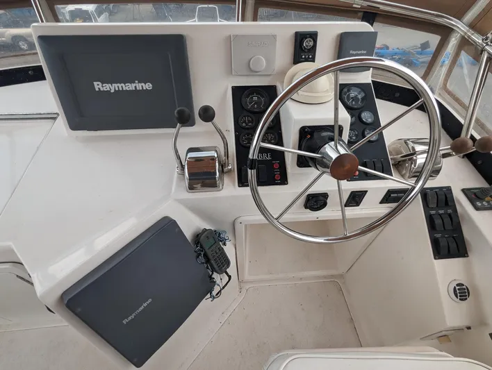  Yacht Photos Pics 2003 Sabre 36 Flybridge helm with Raymarine navigation equipment and steering wheel.