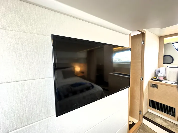 Grand Cru Yacht Photos Pics Flat-screen TV in a 2017 Prestige 500 S yacht interior, near a cozy bedroom and bathroom.