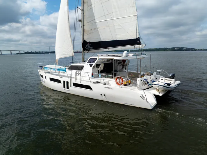 Walkabout Yacht Photos Pics 2019 Royal Cape Catamarans Majestic 530 sailing on calm waters under cloudy skies.