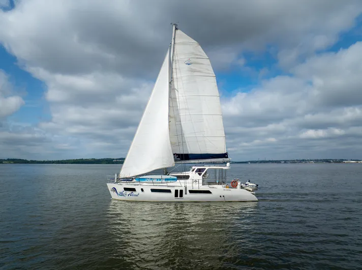 Walkabout Yacht Photos Pics 2019 Royal Cape Catamarans Majestic 530 sailing on calm waters under cloudy skies.