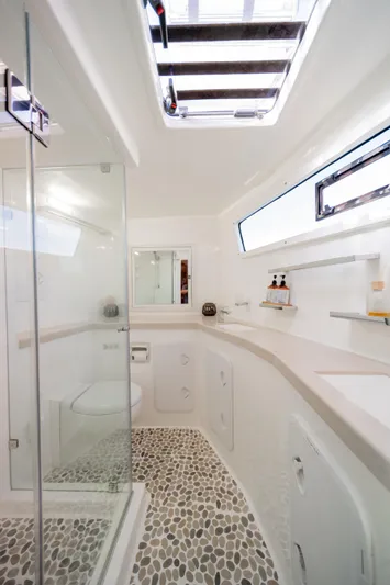 Walkabout Yacht Photos Pics Luxurious bathroom in 2019 Royal Cape Catamarans Majestic 530 with modern fixtures and pebble flooring.