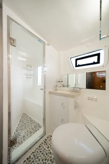 Walkabout Yacht Photos Pics Luxurious bathroom in 2019 Royal Cape Catamarans Majestic 530 with modern fixtures and pebble flooring.