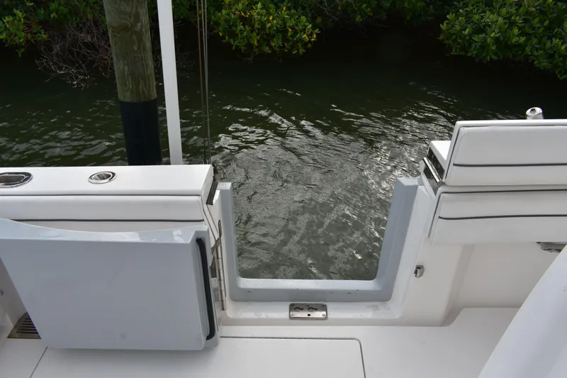 Low Key Yacht Photos Pics Valhalla V-33 boat stern view, open transom door, water and greenery in background.