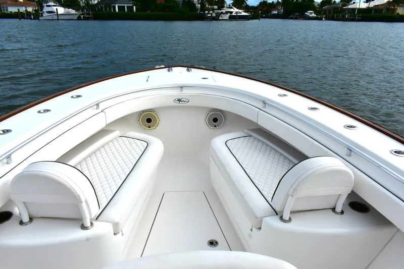 Low Key Yacht Photos Pics 2021 Valhalla V-33 boat interior with white seating, on calm water.