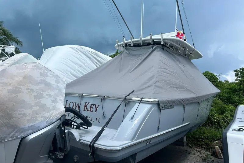 Low Key Yacht Photos Pics 2021 Valhalla V-33 boat covered, parked outdoors, with stormy sky background.