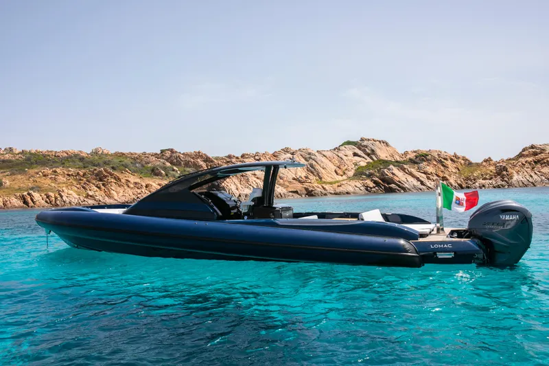 Granturismo 14.0 X Yacht Photos Pics 2024 Lomac GranTurismo 14.0 boat on clear turquoise water near rocky coastline.