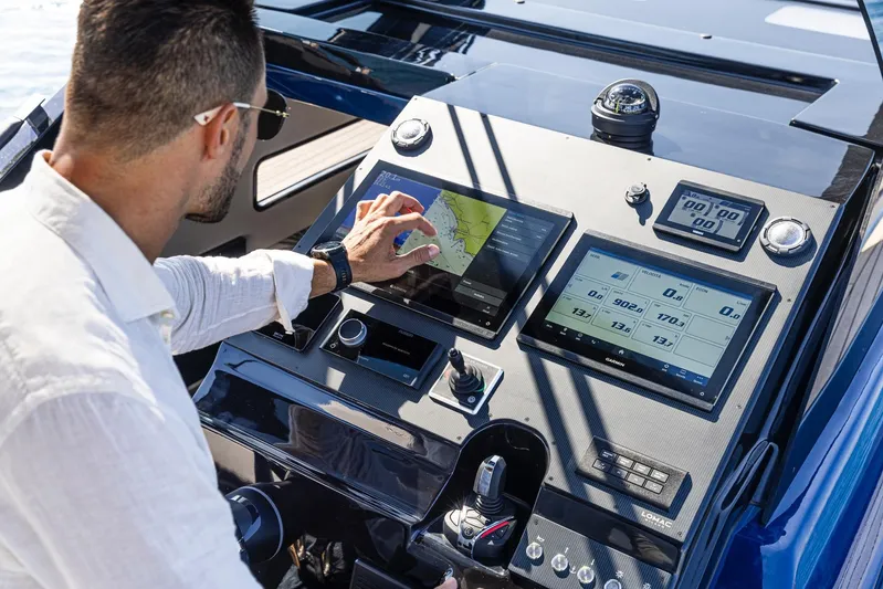 Granturismo 14.0 X Yacht Photos Pics Man operating 2024 Lomac GranTurismo 14.0 boat's advanced touchscreen navigation system.