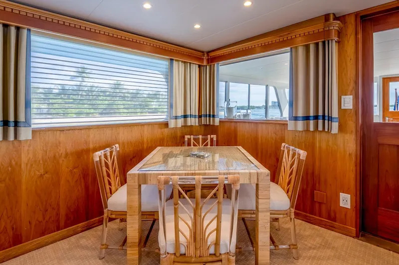 Stoneface Yacht Photos Pics Cozy dining area on a 1978 Burger Custom yacht with wooden decor and large windows.