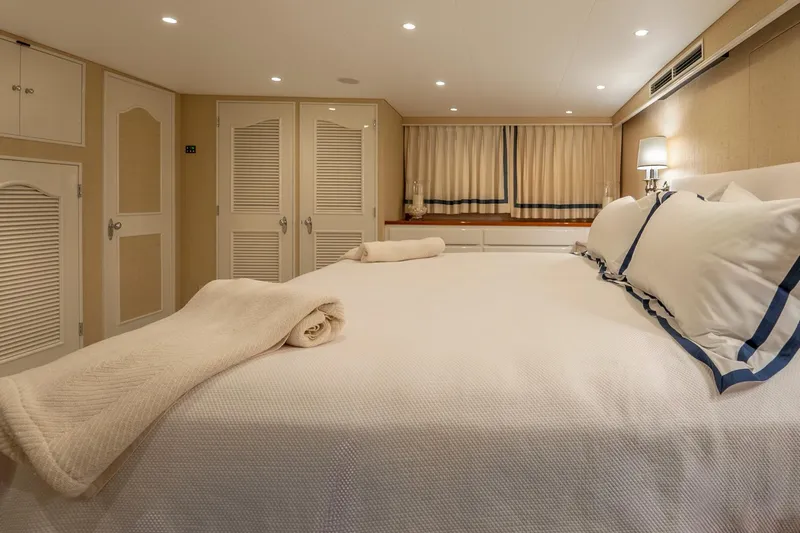 Stoneface Yacht Photos Pics Luxurious bedroom interior on a 1978 custom Burger yacht, featuring elegant bedding and soft lighting.