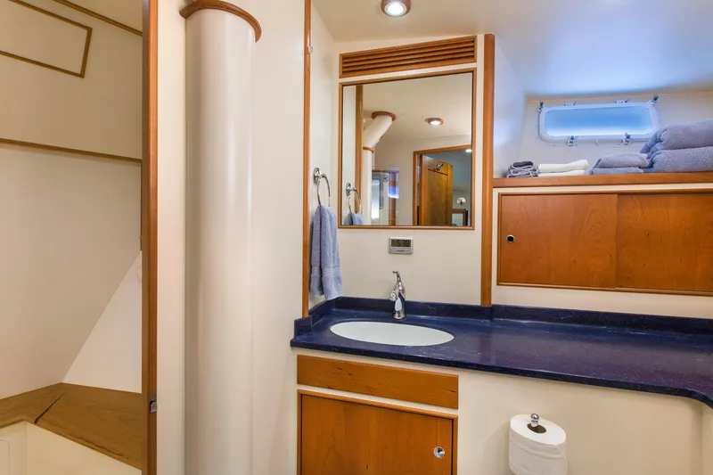 Stoneface Yacht Photos Pics Luxurious yacht bathroom with wooden cabinets, blue countertop, and modern fixtures, 1978 Burger Custom.