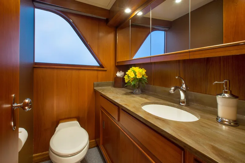 Stoneface Yacht Photos Pics Luxurious wooden bathroom interior on a 1978 Burger yacht with modern fixtures and floral decor.