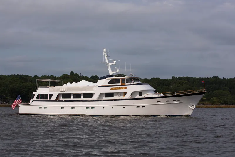 Stoneface Yacht Photos Pics Classic 1978 Burger yacht cruising on a calm river with lush green shoreline.