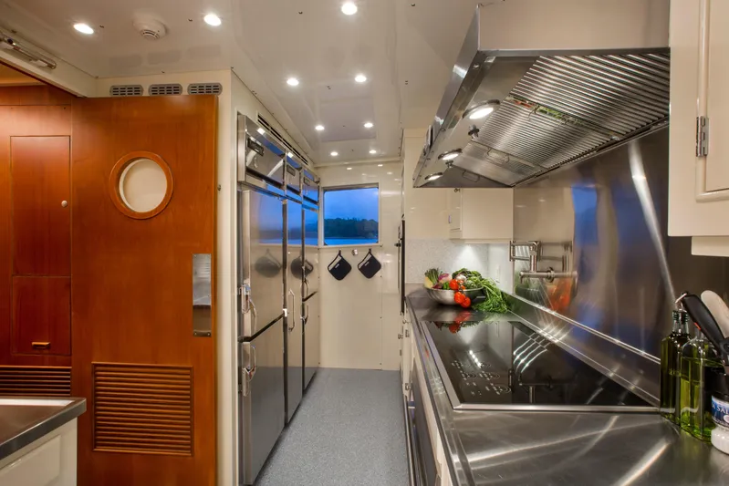 Stoneface Yacht Photos Pics Modern yacht kitchen with stainless steel appliances, wooden accents, and fresh vegetables on the counter.