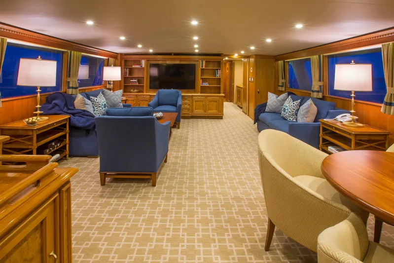 Stoneface Yacht Photos Pics Luxurious yacht interior with blue sofas, wooden furniture, and ambient lighting, 1978 Burger model.