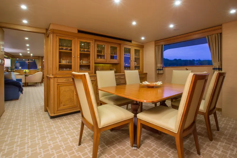 Stoneface Yacht Photos Pics Luxurious yacht dining area with wooden table, elegant chairs, and glass cabinet, 1978 Burger model.