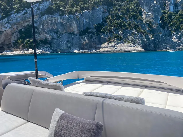 Good Vibes Yacht Photos Pics Luxurious 2020 Pershing 62' yacht with scenic ocean and cliffside view.