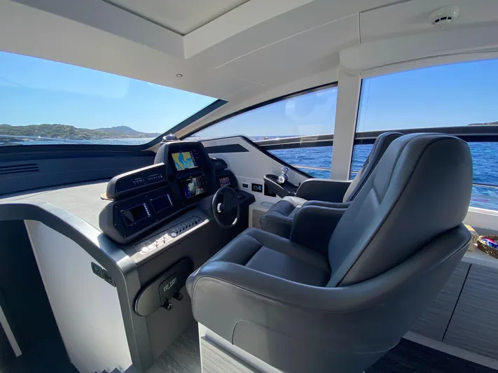 Good Vibes Yacht Photos Pics Luxurious interior of a 2020 Pershing 62' yacht with modern helm and seating.