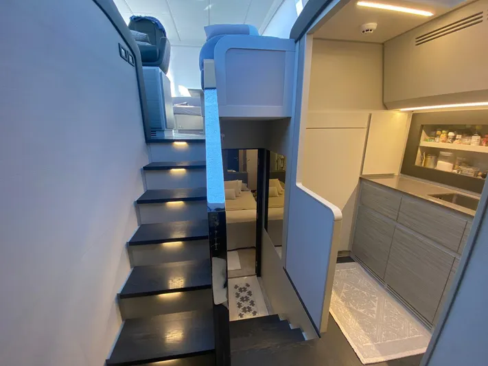 Good Vibes Yacht Photos Pics Interior of 2020 Pershing 62' yacht, featuring modern stairs and sleek kitchen area.