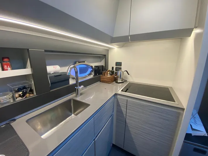 Good Vibes Yacht Photos Pics Modern kitchen interior on a 2020 Pershing 62' yacht, featuring sleek cabinetry and appliances.