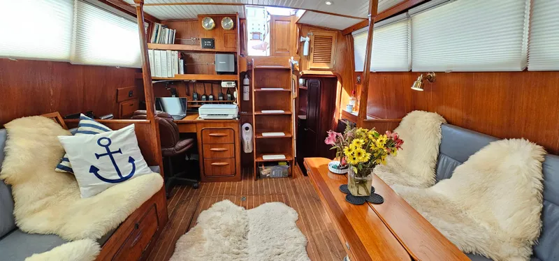 Burgoo Yacht Photos Pics Interior of 1980 Gulfstar 47 Sailmaster, featuring cozy seating, nautical decor, and wooden finishes.