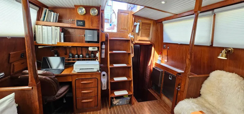 Burgoo Yacht Photos Pics Interior of 1980 Gulfstar 47 Sailmaster, featuring wooden decor, desk, and cozy seating area.