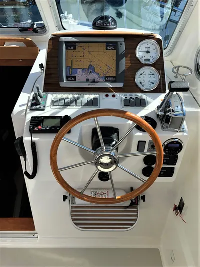 Lady In Blue Yacht Photos Pics Helm of 2012 Back Cove 30 boat with navigation system and wooden steering wheel.