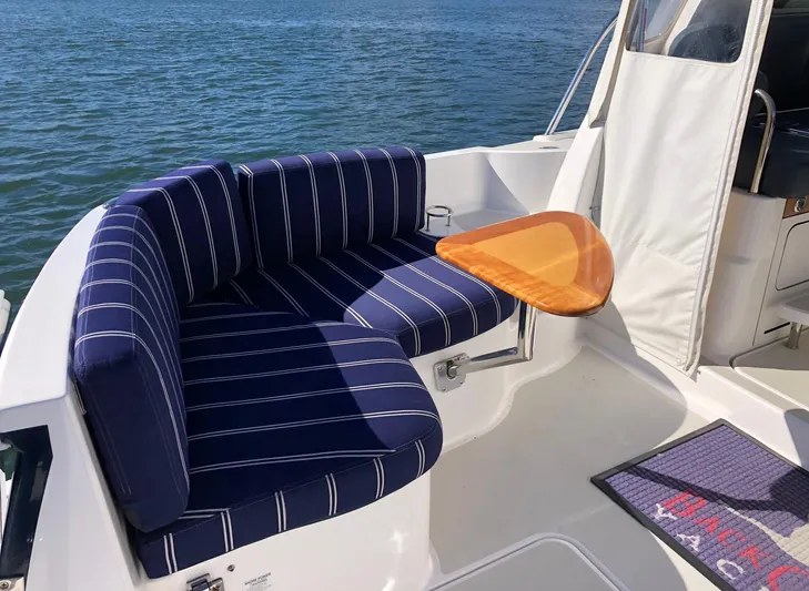 Lady In Blue Yacht Photos Pics 2012 Back Cove 30 boat with striped seating and wooden table on deck.