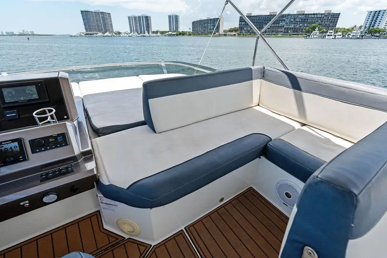 Sea Whisperer Yacht Photos Pics Galeon 500 Fly 2019 yacht interior with cushioned seating and control panel, overlooking waterfront.