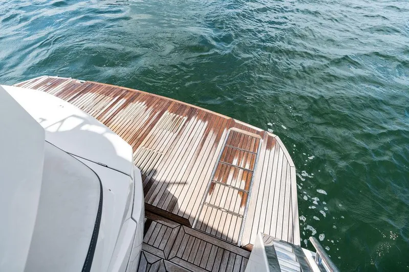Sea Whisperer Yacht Photos Pics Galeon 500 Fly 2019 yacht's wooden deck overlooking the ocean water.