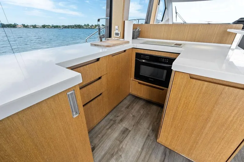 Sea Whisperer Yacht Photos Pics Modern kitchen interior on 2019 Galeon 500 Fly yacht with wood cabinetry and ocean view.