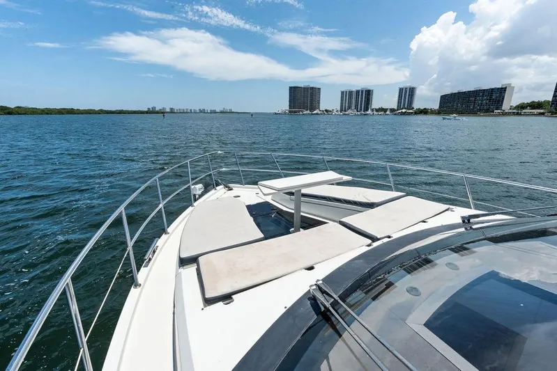 Sea Whisperer Yacht Photos Pics 2019 Galeon 500 Fly yacht deck with sunbeds, overlooking coastal skyline.