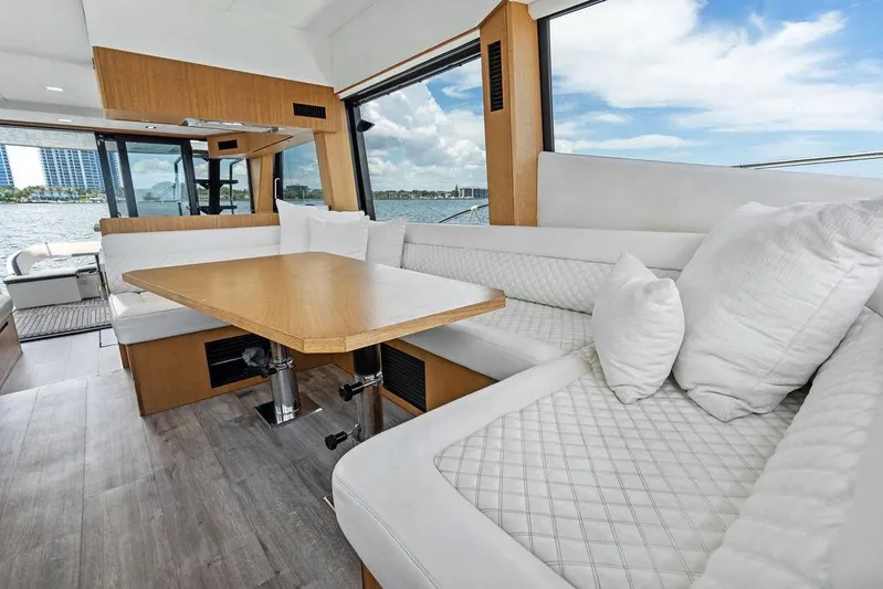 Sea Whisperer Yacht Photos Pics Luxurious interior of 2019 Galeon 500 Fly yacht with elegant seating and wooden table.