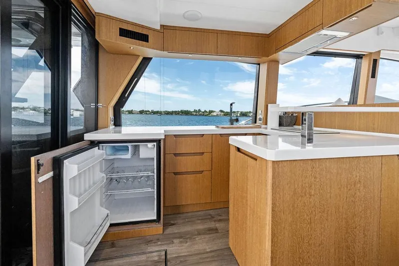 Sea Whisperer Yacht Photos Pics Modern kitchen interior on 2019 Galeon 500 Fly yacht with open fridge and scenic window view.